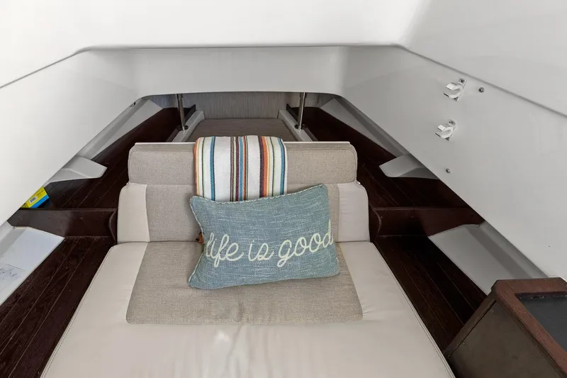  Yacht Photos Pics 2021 Pursuit S 328 Sport cabin interior with cushion and striped blanket.