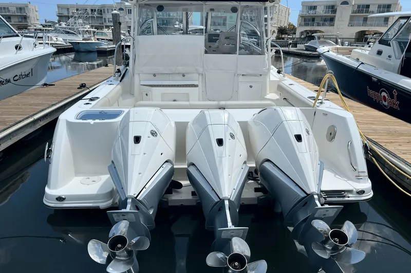  Yacht Photos Pics 2022 Boston Whaler 345 Conquest with triple outboard engines docked at marina.
