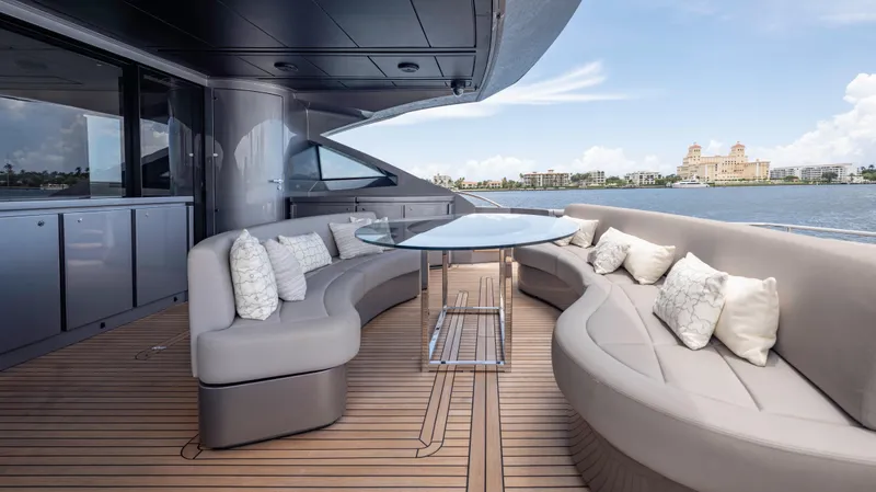  Yacht Photos Pics Luxurious 2021 Pershing 108 yacht deck with elegant seating and scenic waterfront view.