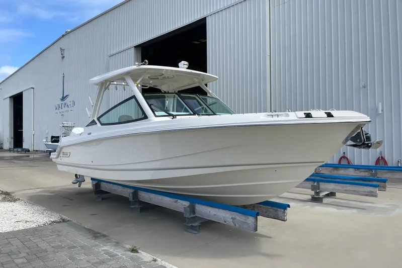 Only 88 Hours! Yacht Photos Pics 2023 Boston Whaler 280 Vantage boat on display outside a large warehouse.