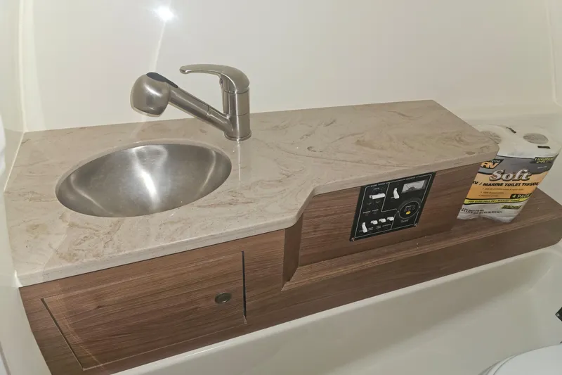 Only 88 Hours! Yacht Photos Pics 2023 Boston Whaler 280 Vantage boat bathroom sink with control panel and toilet paper.