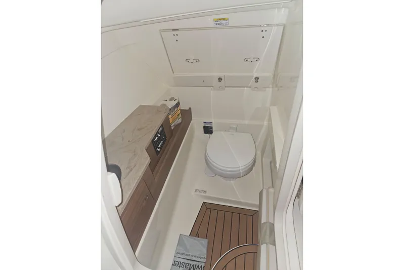 Only 88 Hours! Yacht Photos Pics 2023 Boston Whaler 280 Vantage boat interior bathroom with toilet and wooden flooring.