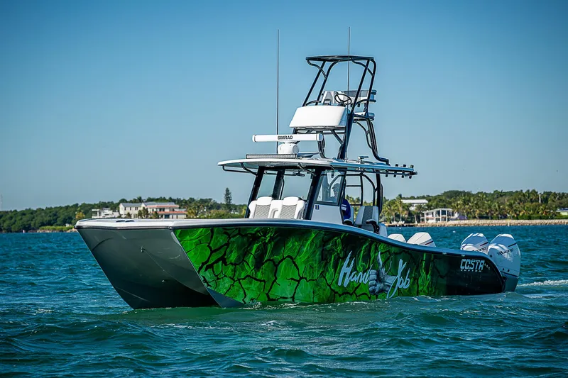  Yacht Photos Pics 2024 Costa Custom Boats 34 cruising on blue water with vibrant green hull design.