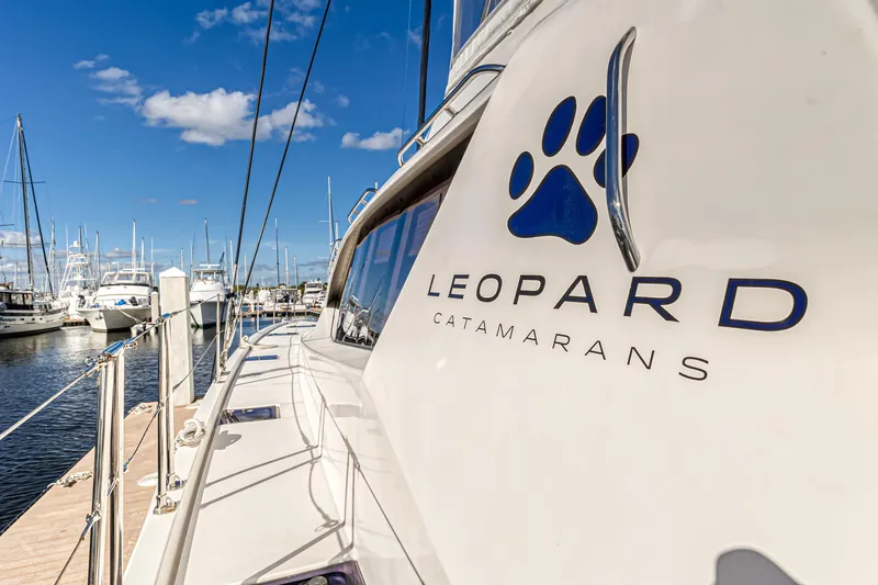 Aquarius Yacht Photos Pics Leopard 58 catamaran docked at marina, showcasing logo and sleek design.