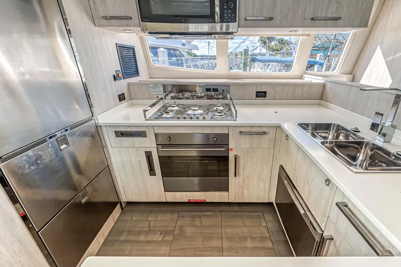 Aquarius Yacht Photos Pics Modern kitchen in a 2016 Leopard 58 yacht with stainless steel appliances and ample counter space.