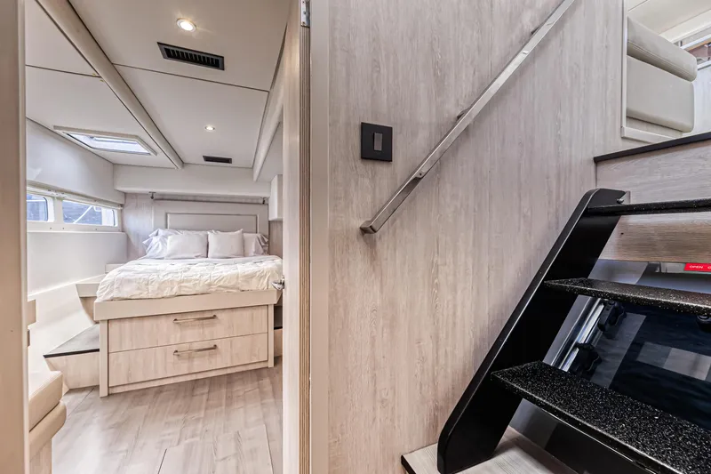 Aquarius Yacht Photos Pics Luxurious interior of 2016 Leopard 58 yacht featuring a cozy bedroom and modern staircase.