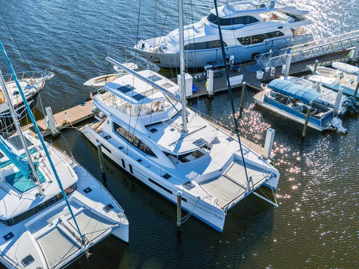 Aquarius Yacht Photos Pics Luxurious Leopard 58 catamaran docked at marina, surrounded by other boats, 2016 model.