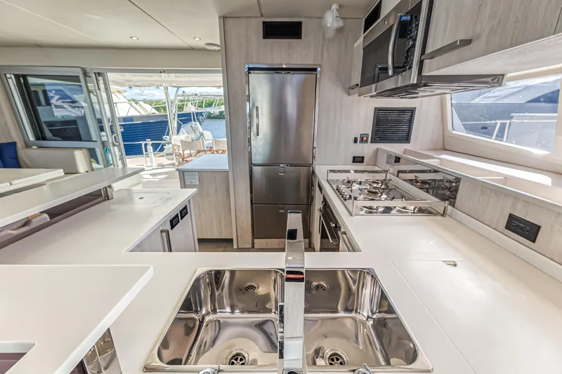 Aquarius Yacht Photos Pics Modern kitchen interior on a 2016 Leopard 58 yacht, featuring stainless steel appliances and sleek countertops.