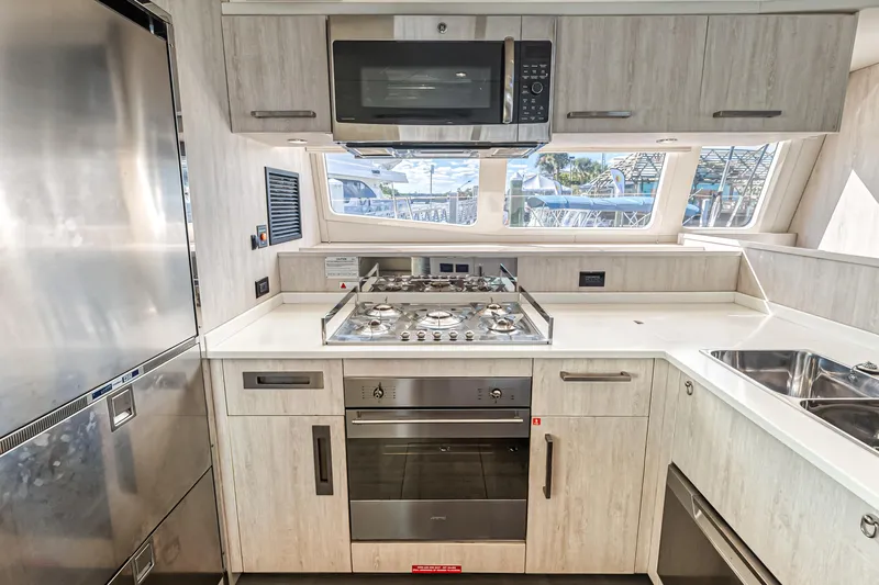 Aquarius Yacht Photos Pics Modern kitchen in a 2016 Leopard 58 yacht with stainless steel appliances and sleek cabinetry.