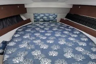  Yacht Photos Pics 2021 Jeanneau NC 895 cabin interior with blue coral-patterned bedding.