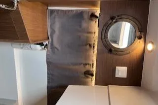  Yacht Photos Pics Interior of 2021 Jeanneau NC 895 boat with porthole and curtain.