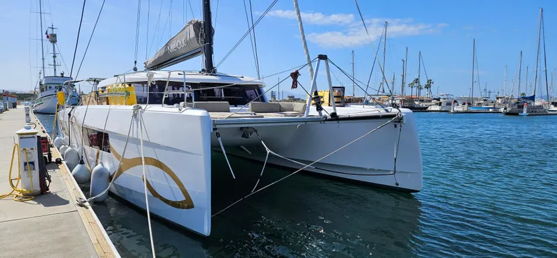 Night Out Yacht Photos Pics 2023 Nautitech 44 Open catamaran docked at a marina under a clear blue sky.