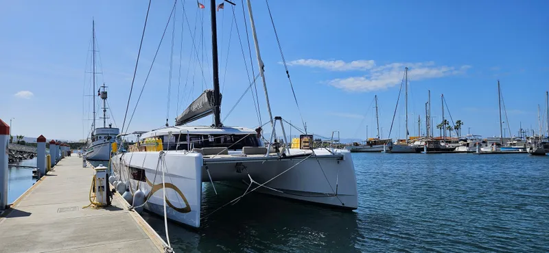 Night Out Yacht Photos Pics 2023 Nautitech 44 Open catamaran docked at a marina under clear blue skies.