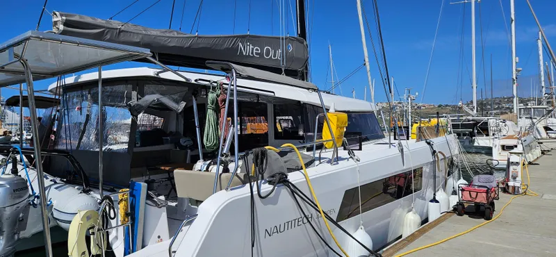 Night Out Yacht Photos Pics 2023 Nautitech 44 Open catamaran docked at a marina under clear blue skies.