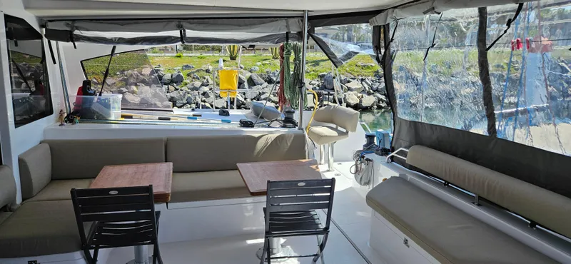 Night Out Yacht Photos Pics 2023 Nautitech 44 Open yacht interior with seating and tables, featuring a scenic outdoor view.