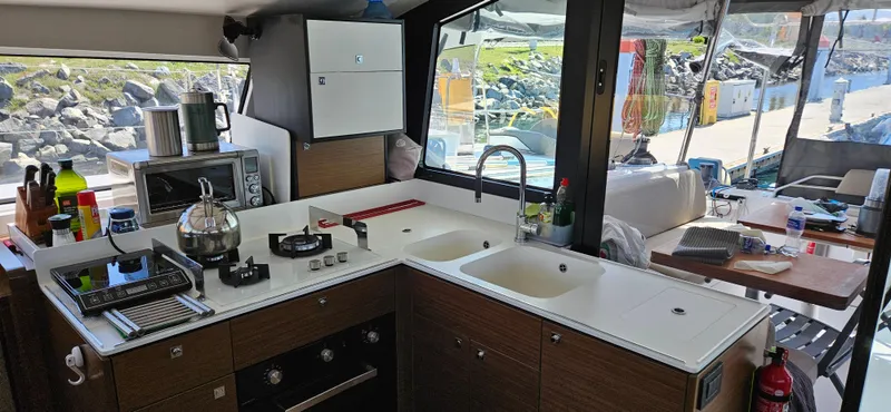 Night Out Yacht Photos Pics Modern kitchen interior of 2023 Nautitech 44 Open yacht, featuring appliances and dual sinks.
