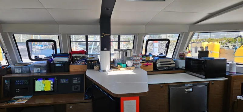 Night Out Yacht Photos Pics Interior of 2023 Nautitech 44 Open catamaran with navigation equipment and kitchen area.