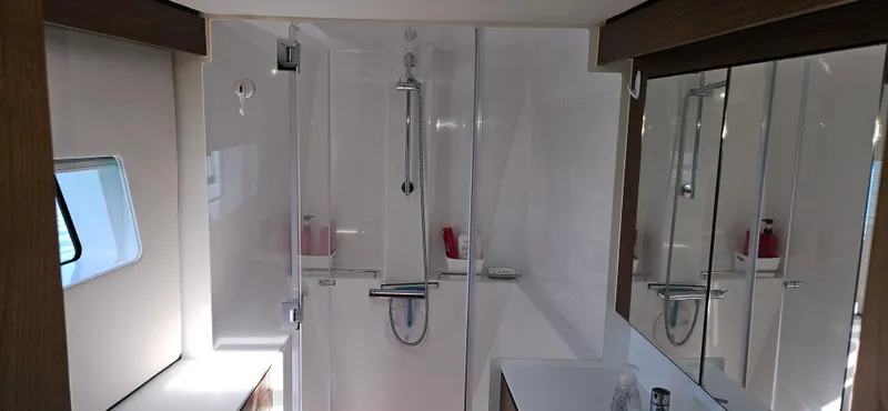 Night Out Yacht Photos Pics Modern bathroom interior of 2023 Nautitech 44 Open yacht, featuring sleek shower and mirrored cabinets.