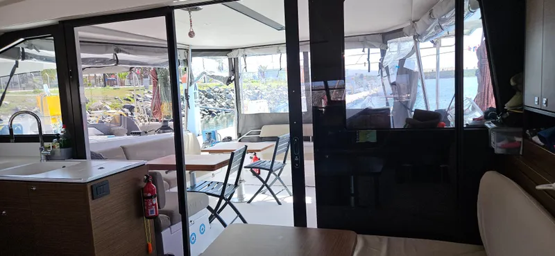 Night Out Yacht Photos Pics Interior view of 2023 Nautitech 44 Open catamaran, featuring modern seating and dining area.