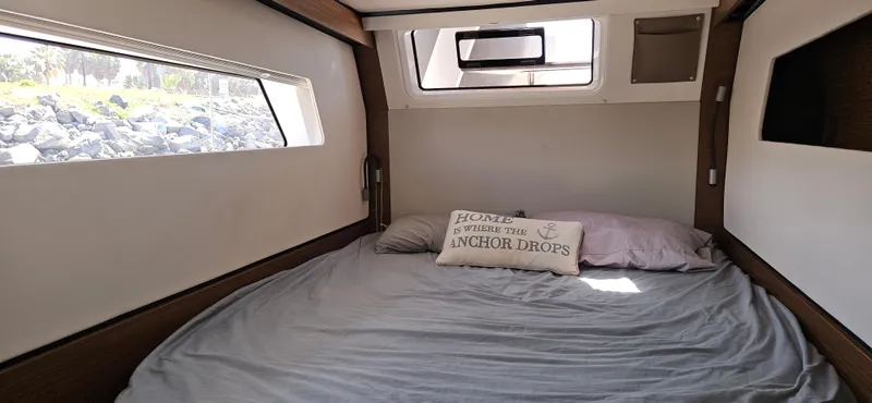 Night Out Yacht Photos Pics Cozy bedroom in 2023 Nautitech 44 Open catamaran with large windows and decorative pillow.
