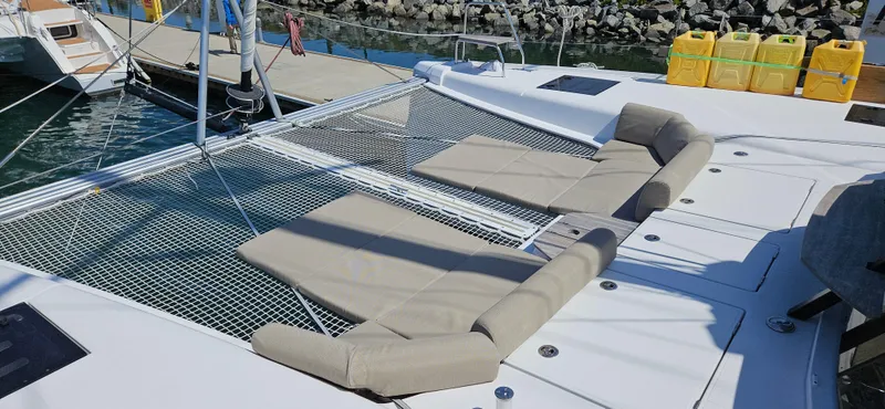 Night Out Yacht Photos Pics 2023 Nautitech 44 Open catamaran with netted deck and cushioned seating.