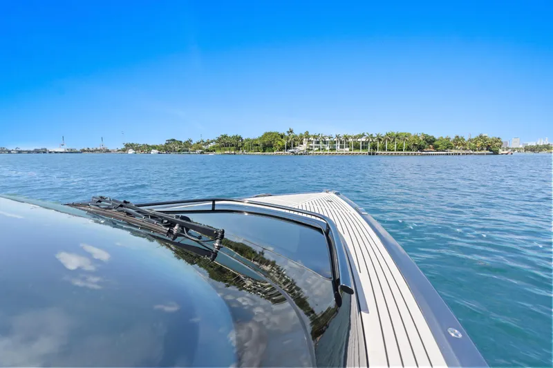  Yacht Photos Pics 2020 Princess R35 yacht cruising on clear blue waters near a lush island.
