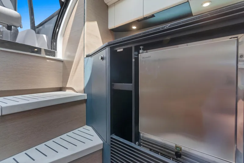  Yacht Photos Pics Modern yacht interior with stainless steel fridge, wooden steps, and sleek cabinetry in Princess R35, 2020.