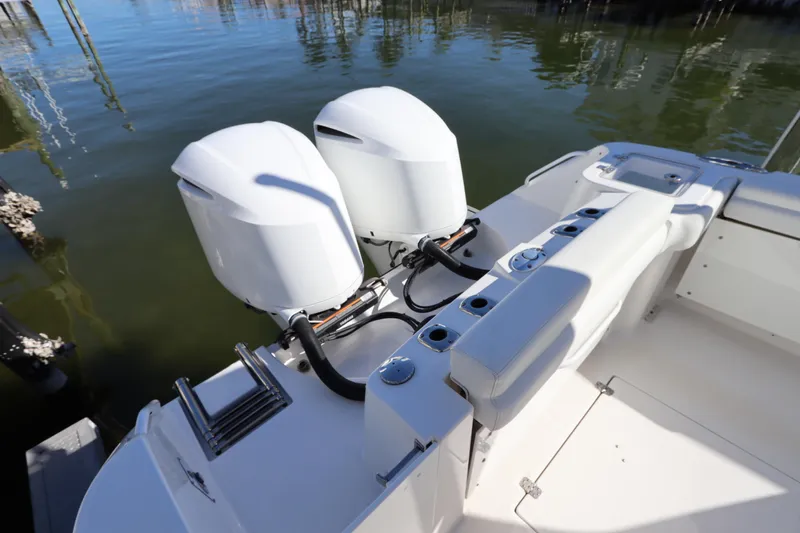  Yacht Photos Pics 2021 Edgewater 262CX Crossover boat with dual outboard engines on calm water.
