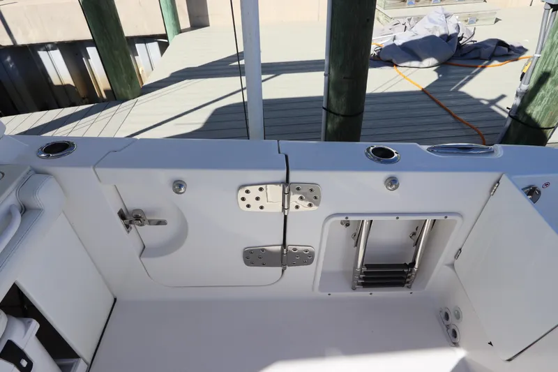  Yacht Photos Pics 2021 Edgewater 262CX Crossover boat deck with storage compartments and ladder.