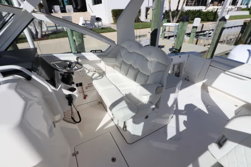  Yacht Photos Pics 2021 Edgewater 262CX Crossover boat interior with white seating and steering wheel.
