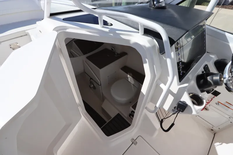  Yacht Photos Pics 2021 Edgewater 262CX Crossover boat interior with helm and compact cabin space.
