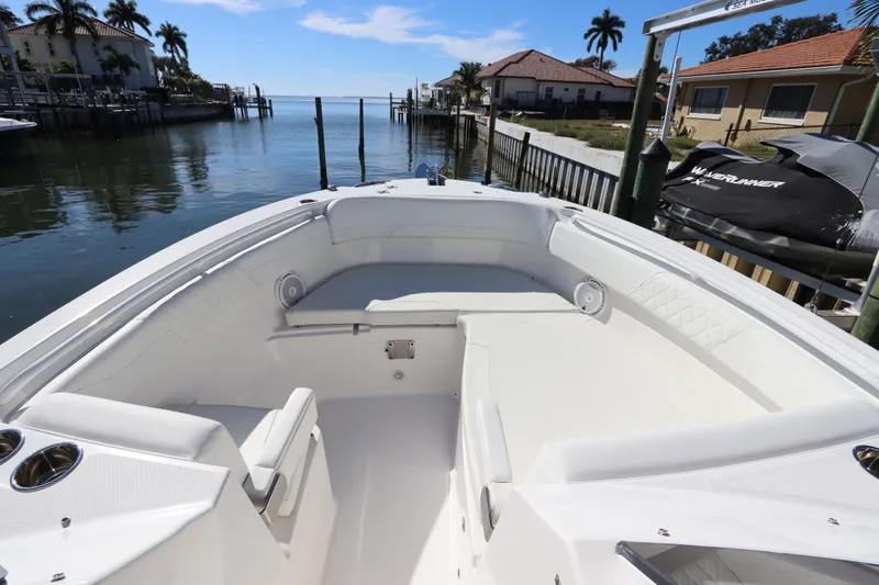  Yacht Photos Pics Bow seating area of 2021 Edgewater 262CX Crossover boat docked by waterfront homes.