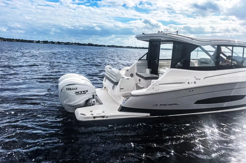 Oh Be Joyful Yacht Photos Pics 2024 Regal 36 XO boat cruising on open water under a partly cloudy sky.