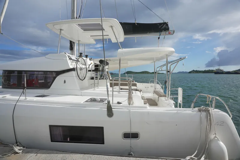 Apres Sail Yacht Photos Pics 2019 Lagoon 42 catamaran docked by the sea, featuring a spacious deck and modern design.