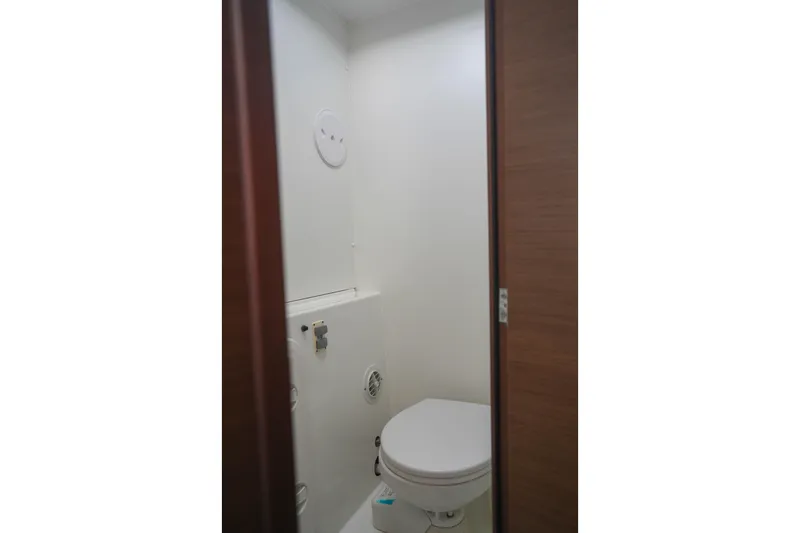 Apres Sail Yacht Photos Pics 2019 Lagoon 42 yacht bathroom interior with white walls and compact toilet.