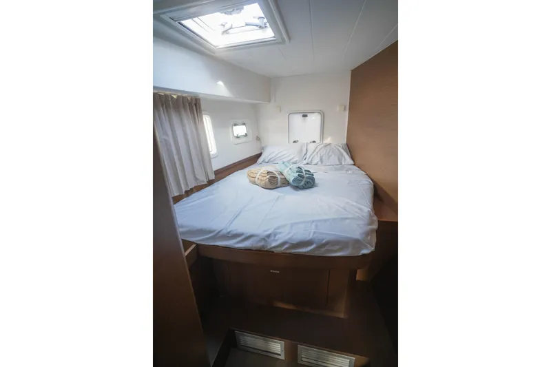 Apres Sail Yacht Photos Pics Cozy bedroom interior of 2019 Lagoon 42 catamaran with skylight and neatly arranged bed.