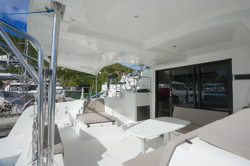 Apres Sail Yacht Photos Pics Luxurious 2019 Lagoon 42 catamaran deck with seating and table, docked in a marina.