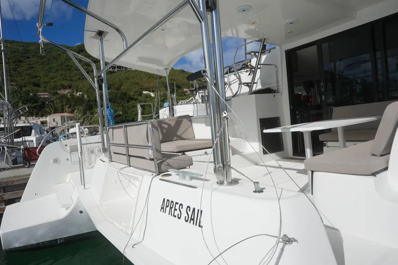 Apres Sail Yacht Photos Pics 2019 Lagoon 42 catamaran with outdoor seating, docked in a scenic marina.