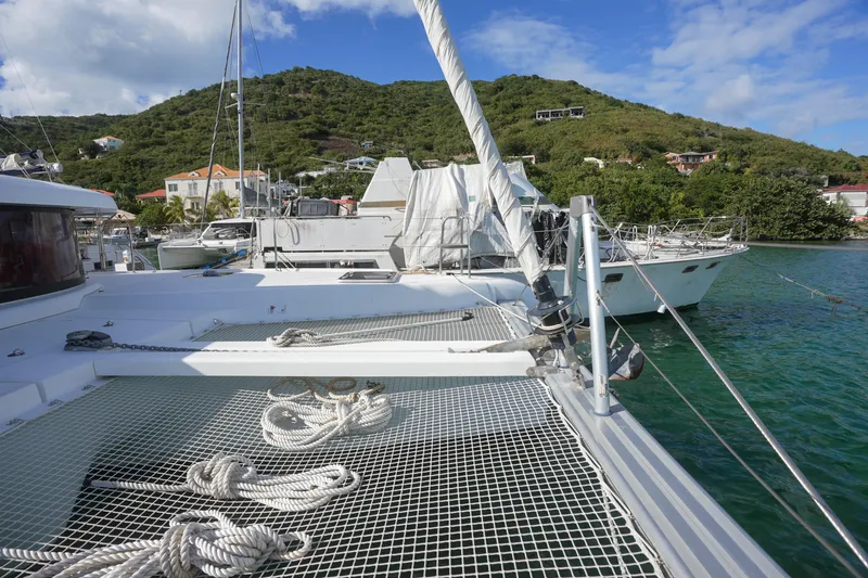 Apres Sail Yacht Photos Pics Catamaran Lagoon 42, 2019 model, docked in scenic marina with lush hillside backdrop.