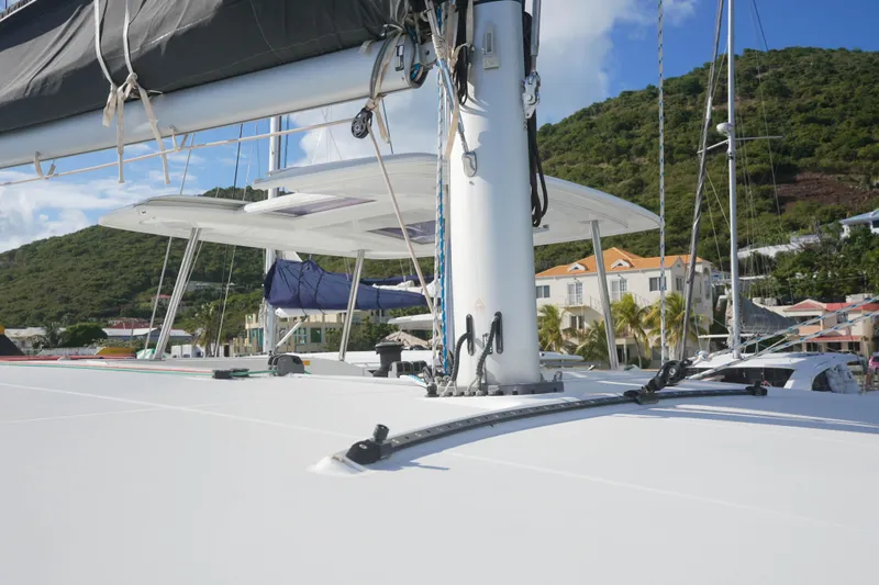 Apres Sail Yacht Photos Pics 2019 Lagoon 42 catamaran docked, showcasing mast and rigging against a scenic hillside backdrop.