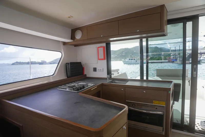 Apres Sail Yacht Photos Pics Interior of 2019 Lagoon 42 yacht kitchen with ocean view through large windows.