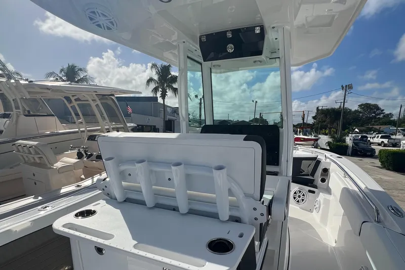252-449 Yacht Photos Pics 2025 Blackfin 252 CC boat interior with rod holders and seating under a clear sky.