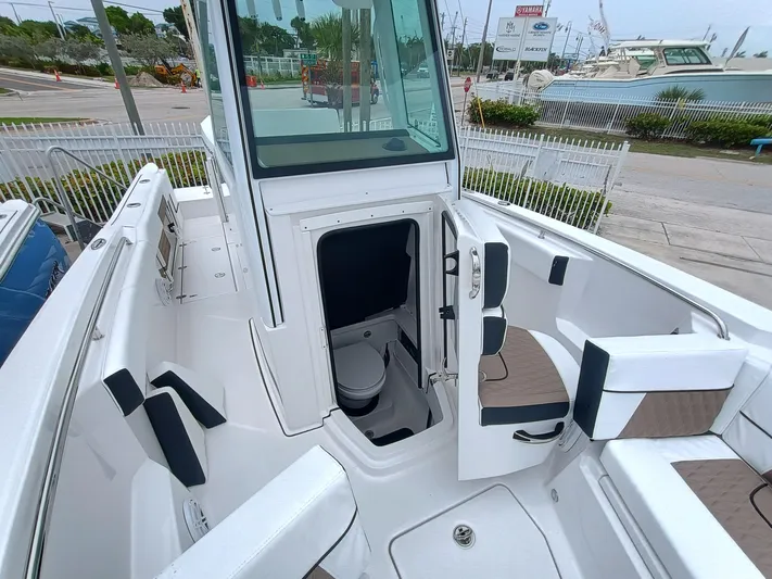 252-449 Yacht Photos Pics 2025 Blackfin 252 CC boat interior with open cabin door and seating area.