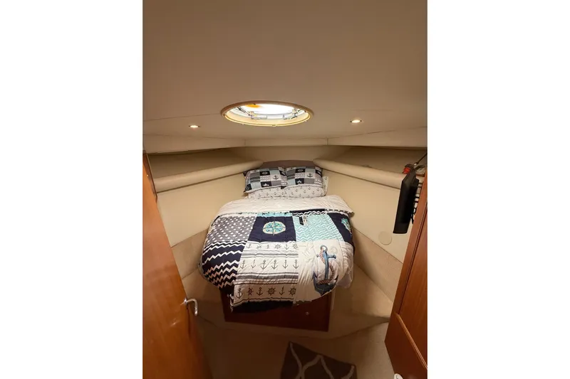  Yacht Photos Pics Cozy bedroom in 2005 Riviera 40 Flybridge yacht with nautical-themed bedding.