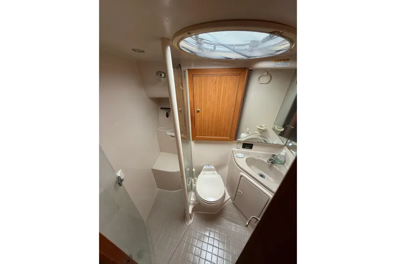  Yacht Photos Pics 2005 Riviera 40 Flybridge yacht bathroom with toilet, sink, and shower.
