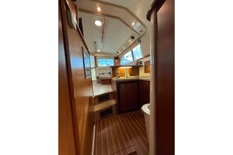 Yacht Photos Pics Interior of 2005 Riviera 40 Flybridge yacht, featuring wood finishes and compact kitchen area.
