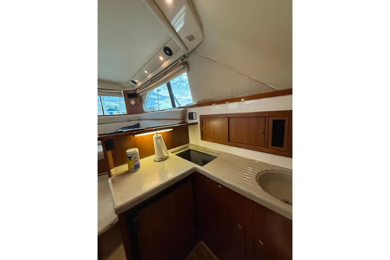  Yacht Photos Pics 2005 Riviera 40 Flybridge yacht interior kitchen with wooden cabinets and countertop.