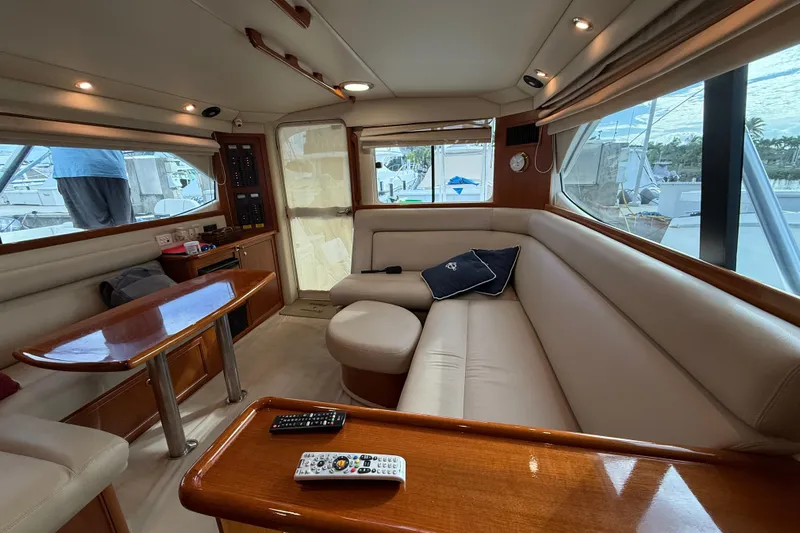  Yacht Photos Pics Luxurious interior of 2005 Riviera 40 Flybridge yacht with plush seating and wooden accents.