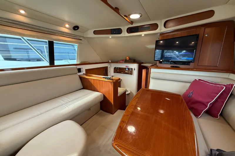 Yacht Photos Pics Luxurious interior of 2005 Riviera 40 Flybridge yacht with plush seating and TV.
