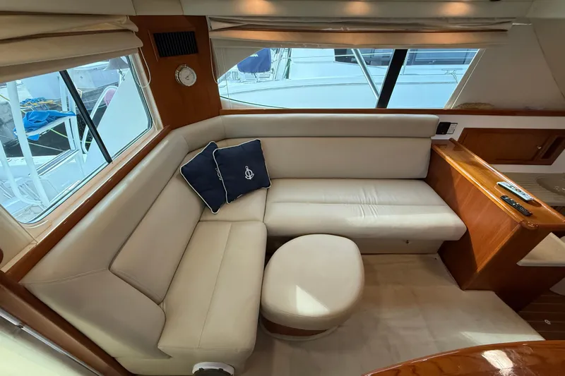  Yacht Photos Pics Luxurious interior of 2005 Riviera 40 Flybridge yacht with cream leather seating and nautical decor.